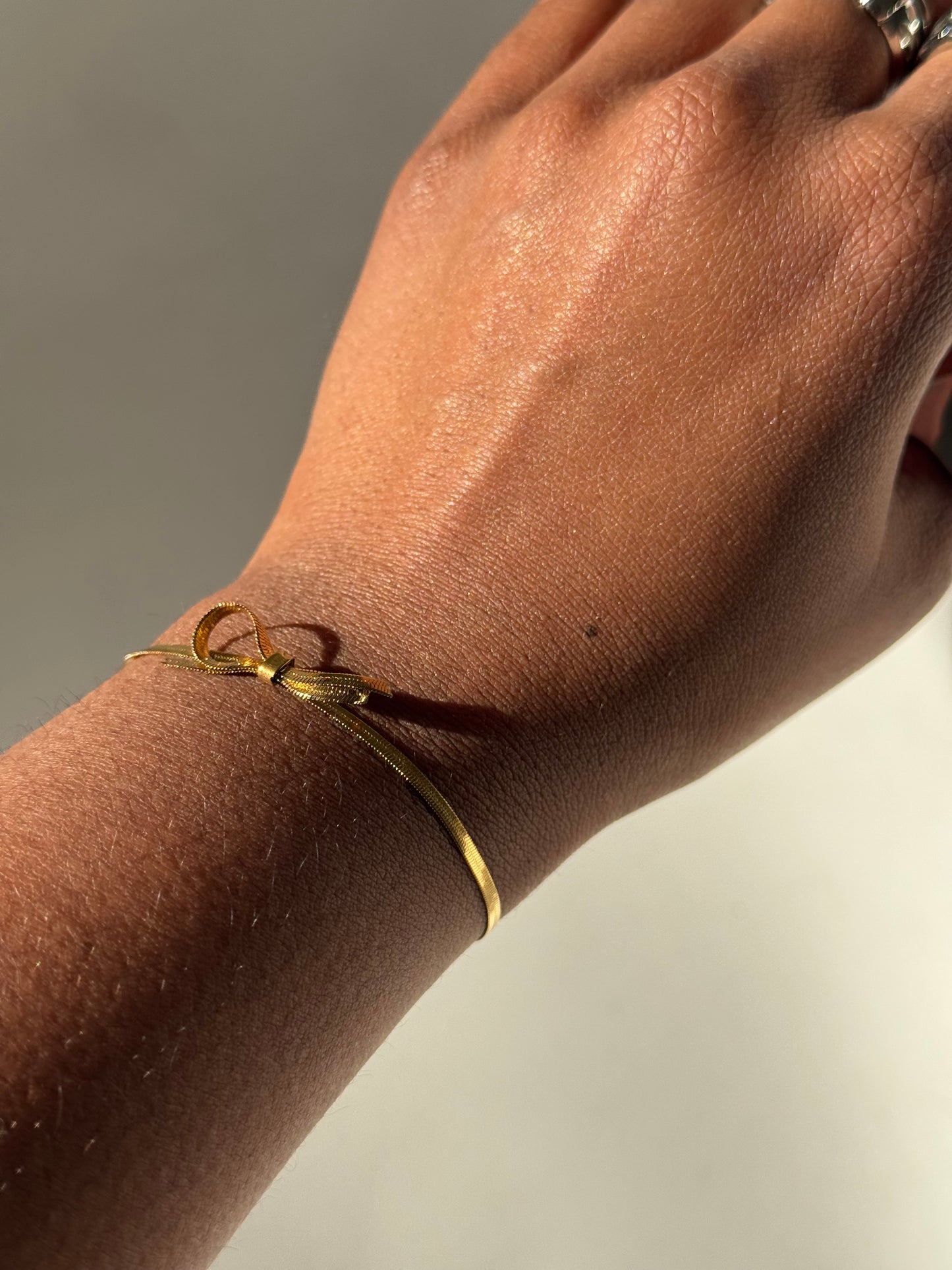 Kinsley Herringbone Stainless Steel Chain Bow Bracelet In Antique Gold